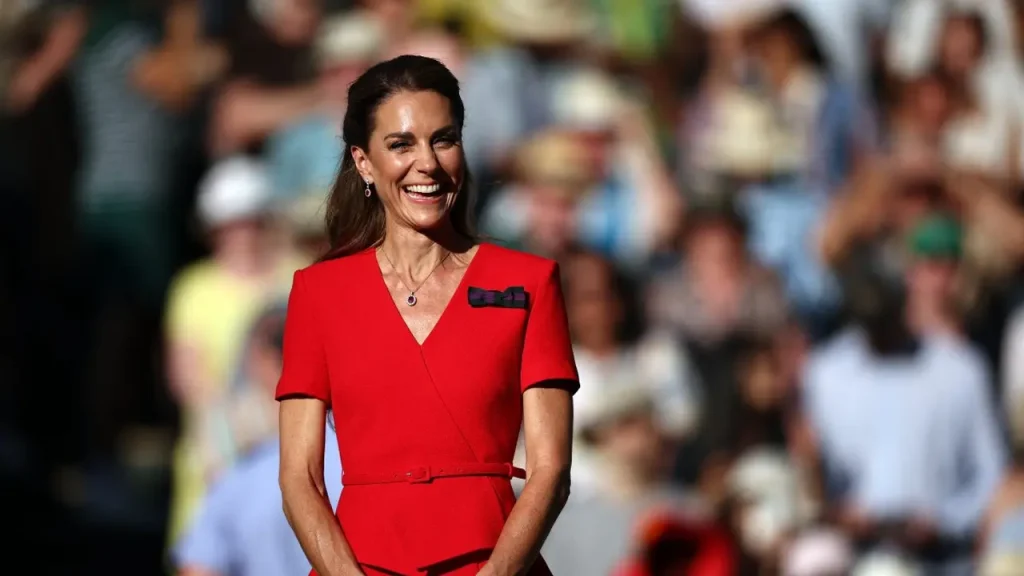 Kate Middleton mengenakan gaun merah elegan saat menghadiri Wimbledon 2026 di Royal Box dengan aksesori mewah dan gaya klasik khas keluarga kerajaan Inggris.