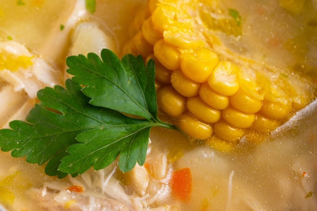 Semangkuk sayur asem Sunda kuah bening berisi jagung, kacang panjang, labu siam, nangka muda, melinjo, dan daging sandung lamur yang disajikan hangat.