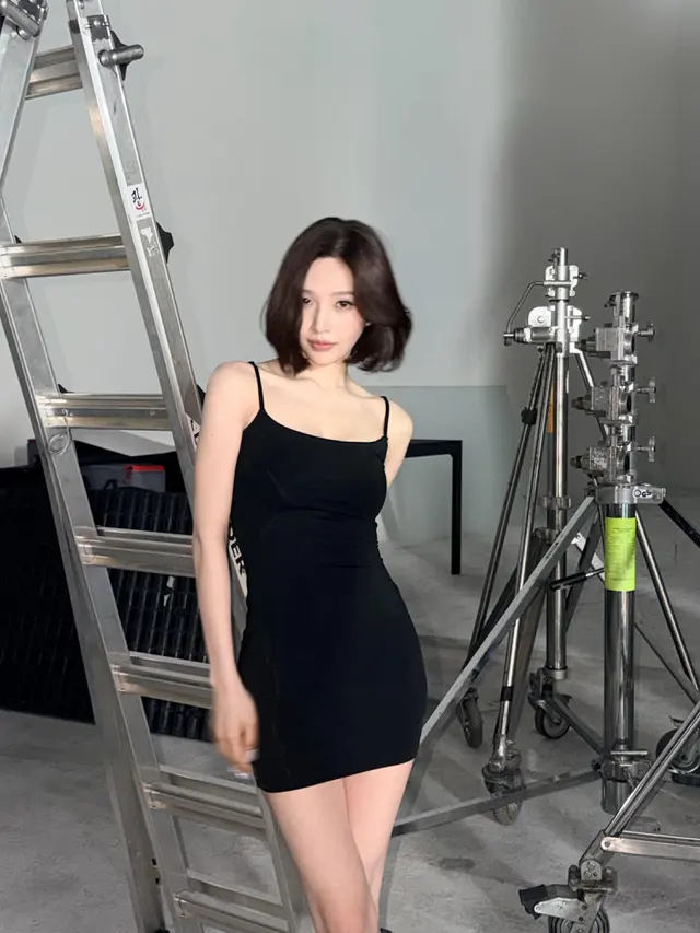 Joy Red Velvet tampil elegan dengan rambut bob pendek sleek dan mini dress hitam